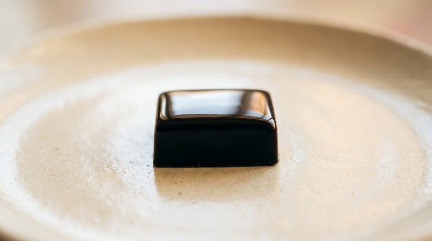 Caraque praline coated in dark chocolate on a chocolatier's tray